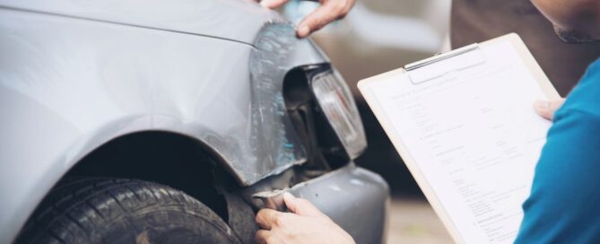Inspector assessing car damage for insurance claim to determine coverage needs in North Carolina