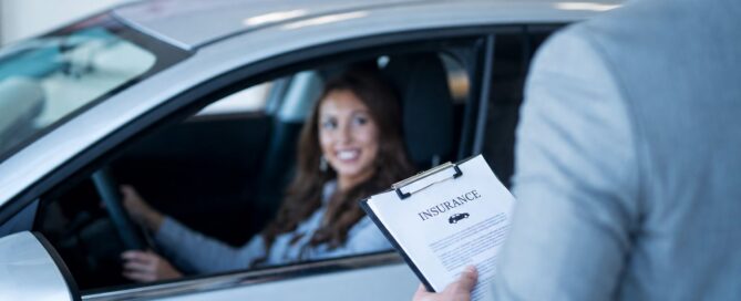 Woman sitting inside a car reviewing and applying for auto insurance